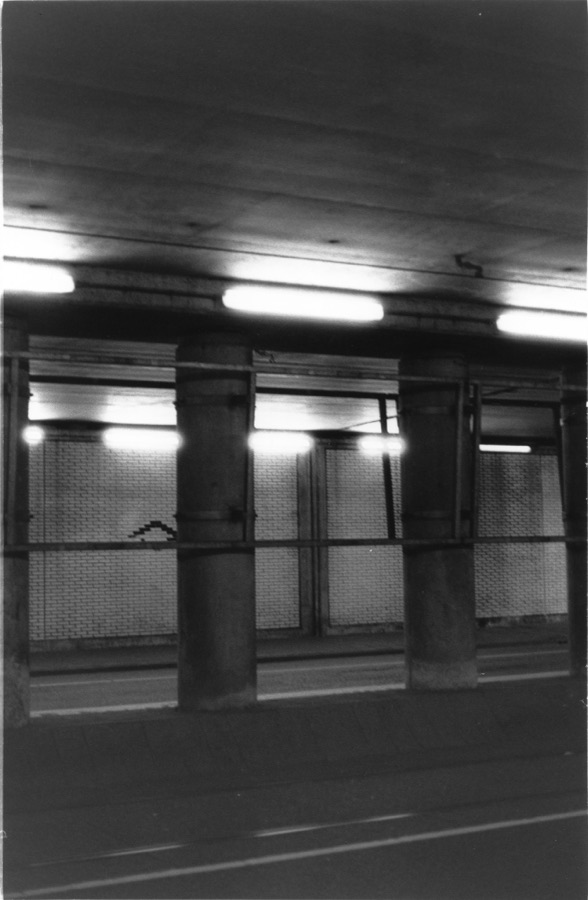 An empty underpass, its columns and strip lights receding into the dark