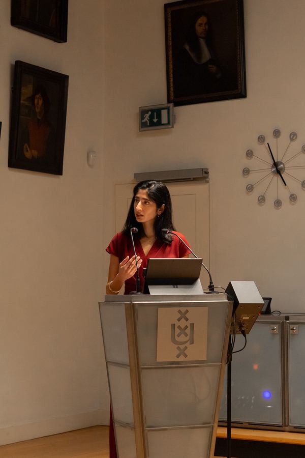 A speaker presenting from the University of Amsterdam lectern