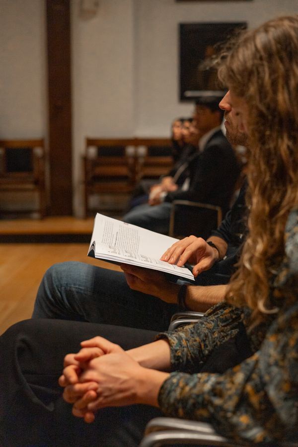 A guest following the ceremony booklet from the audience