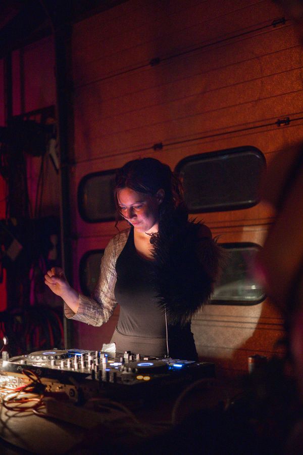 A DJ working the decks in low red light